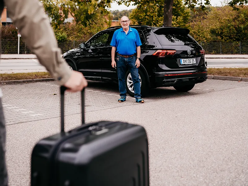 Transfer zum Flughafen - Mann mit Koffer auf dem Weg zum Flughafen