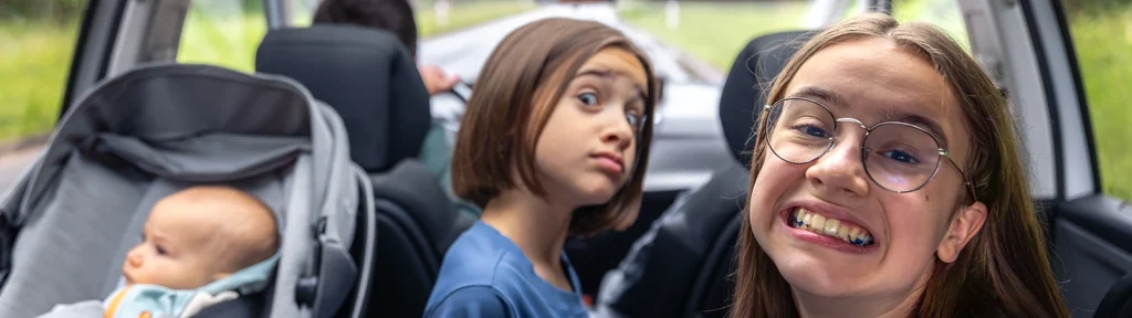 Wochenendtrip mit Kindern - 3 Kinder auf der Rückbank eines Autos