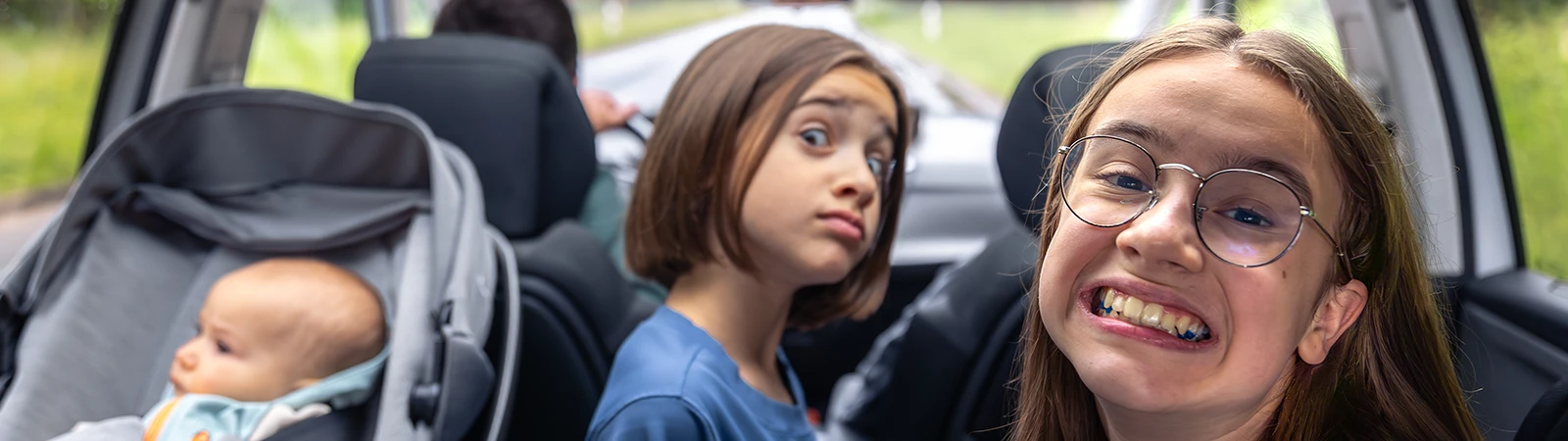 Wochenendtrip mit Kindern - 3 Kinder auf der Rückbank eines Autos