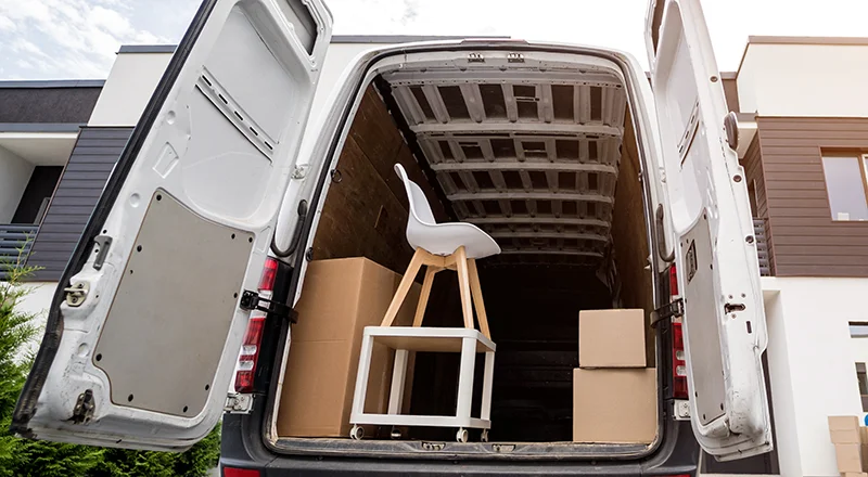 Transporter-Größen Muhr Autoverleih - Transporter beladen mit Umzugskisten, einem Stuhl und einem kleinen Tisch