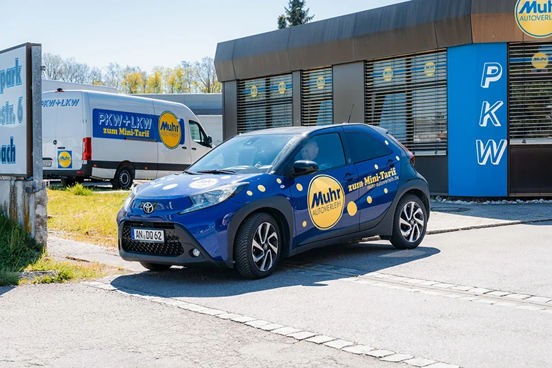 Ladeplanung E-Auto - Muhr E-Auto Mietwagen steht vor einer Muhr Mietstation