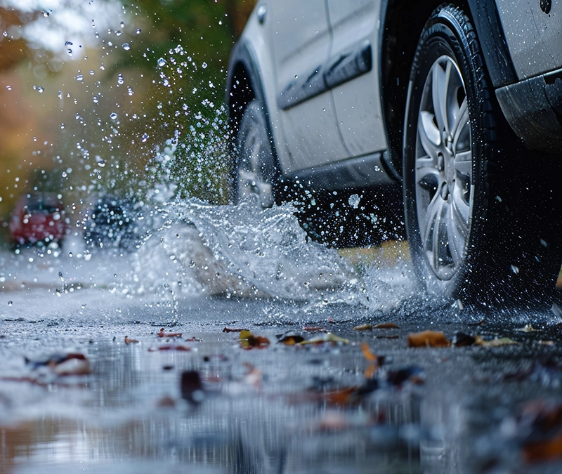 Fahren bei Unwetter - Auto beim Fahren durch eine Pfütze